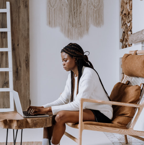 سيدة تعمل على حاسوب محمول في مكتب مشرق